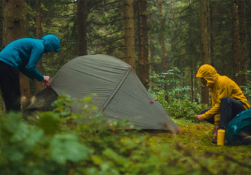 two people putting up a tent